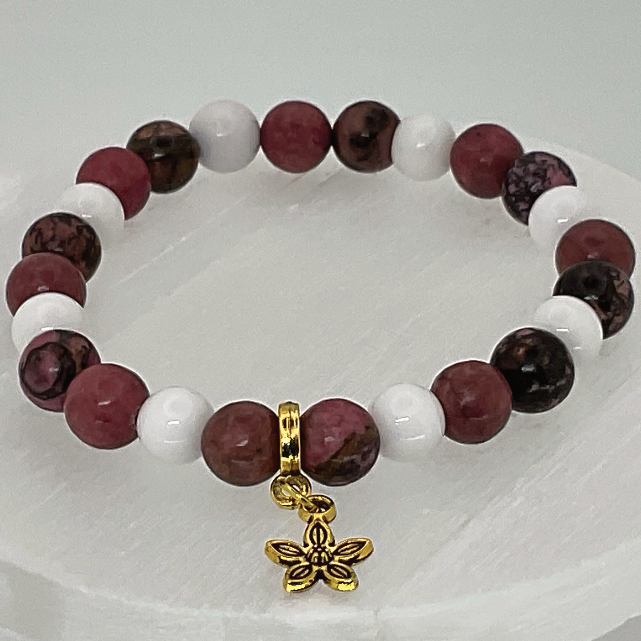 Pulsera de cuarzo lechoso y rodorita con dije de flor dorada