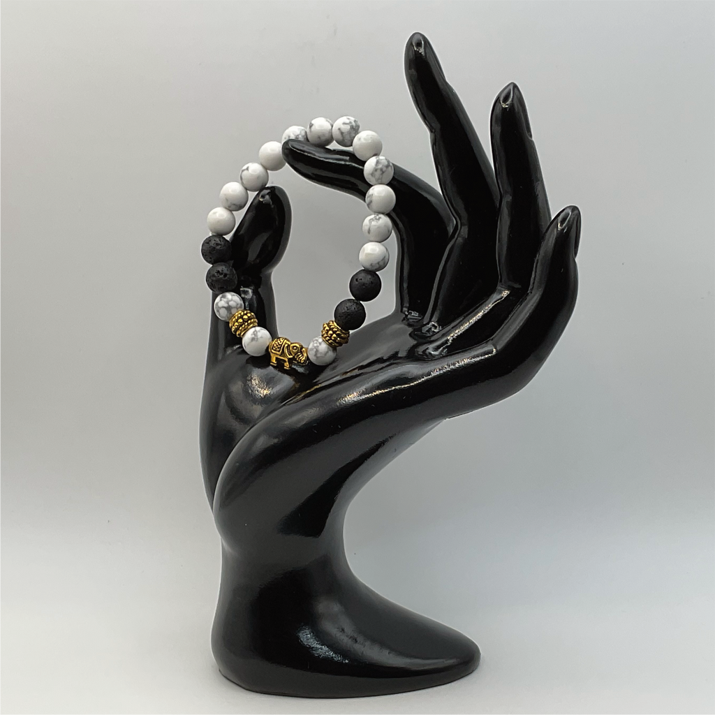 Pulsera con dije de elefante de howlita y lava con espaciadores dorados