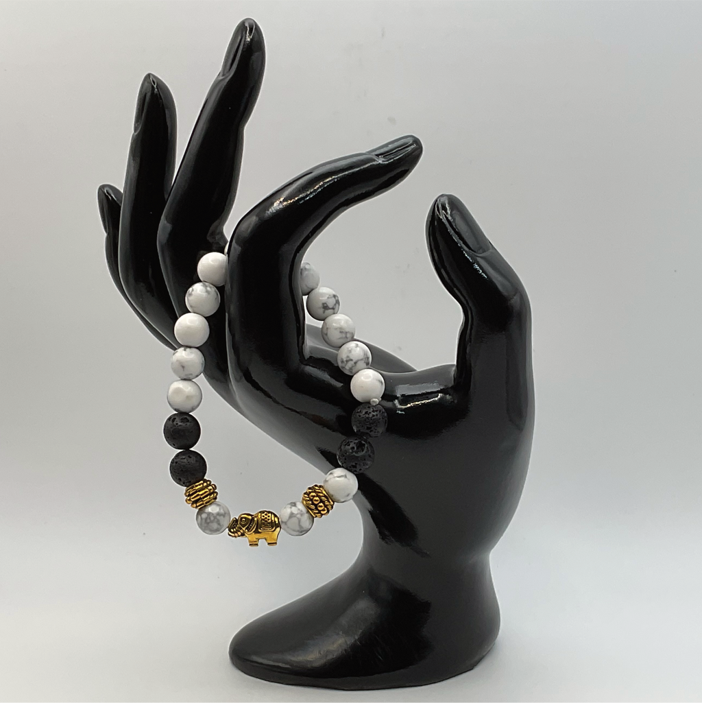 Pulsera con dije de elefante de howlita y lava con espaciadores dorados
