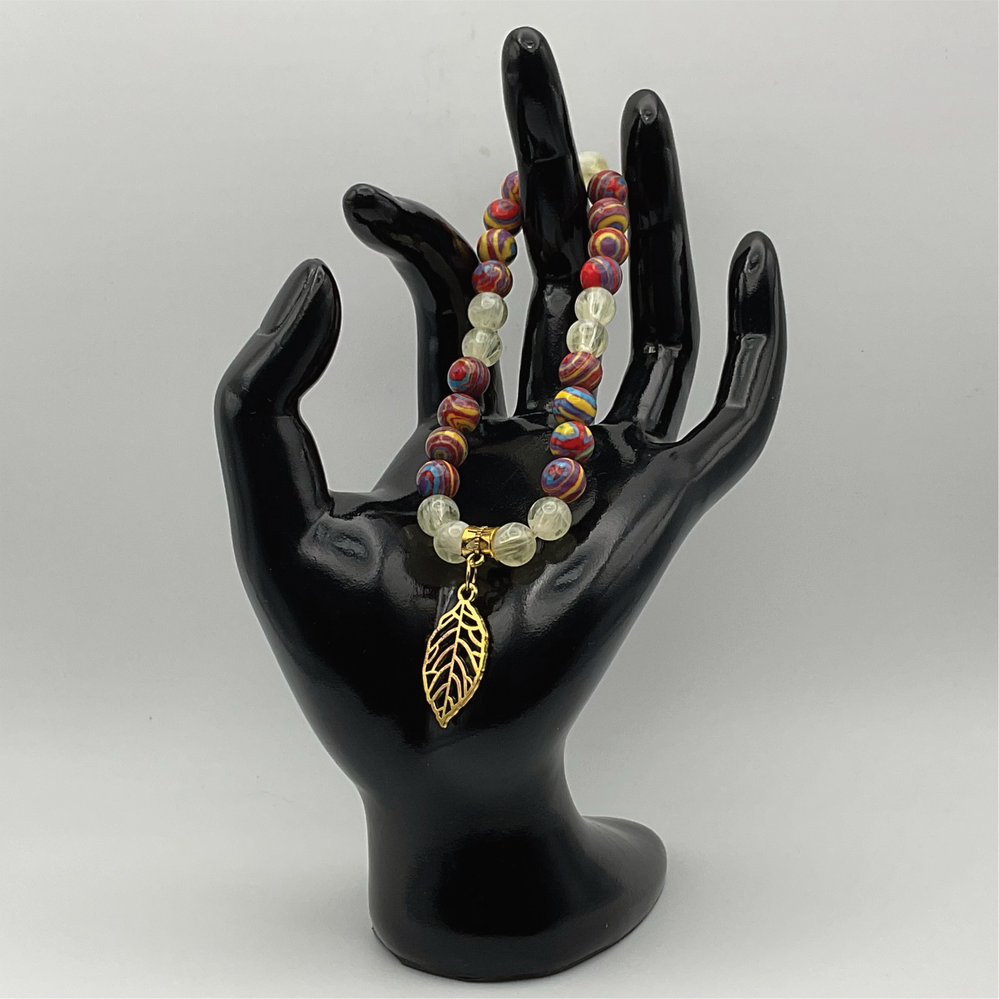 Pulsera con dijes de prehnita y calsilica arcoíris con hoja en tono dorado