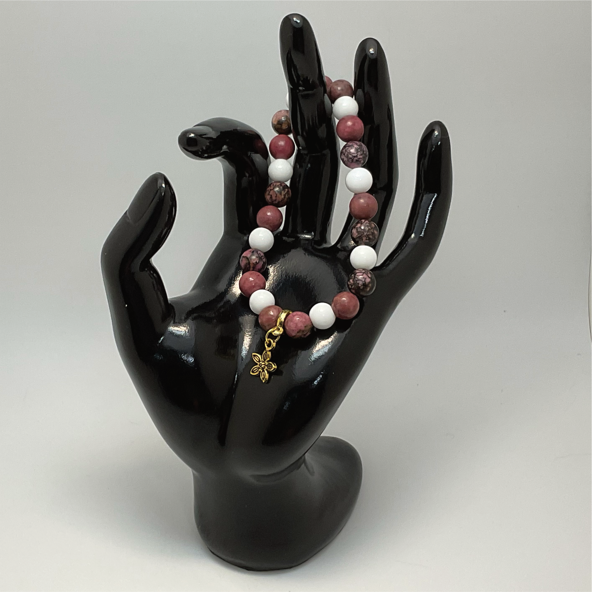 Pulsera de cuarzo lechoso y rodorita con dije de flor dorada
